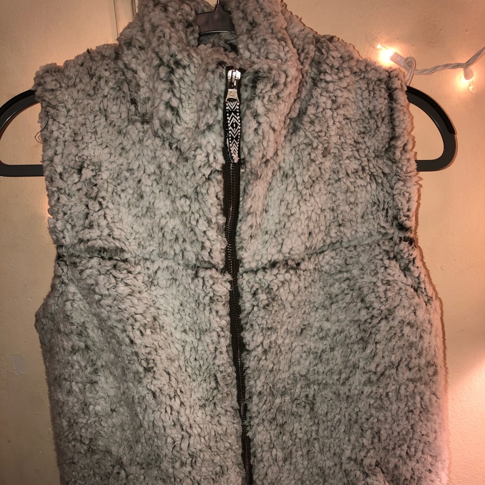 white fuzzy vest with olive green under tone